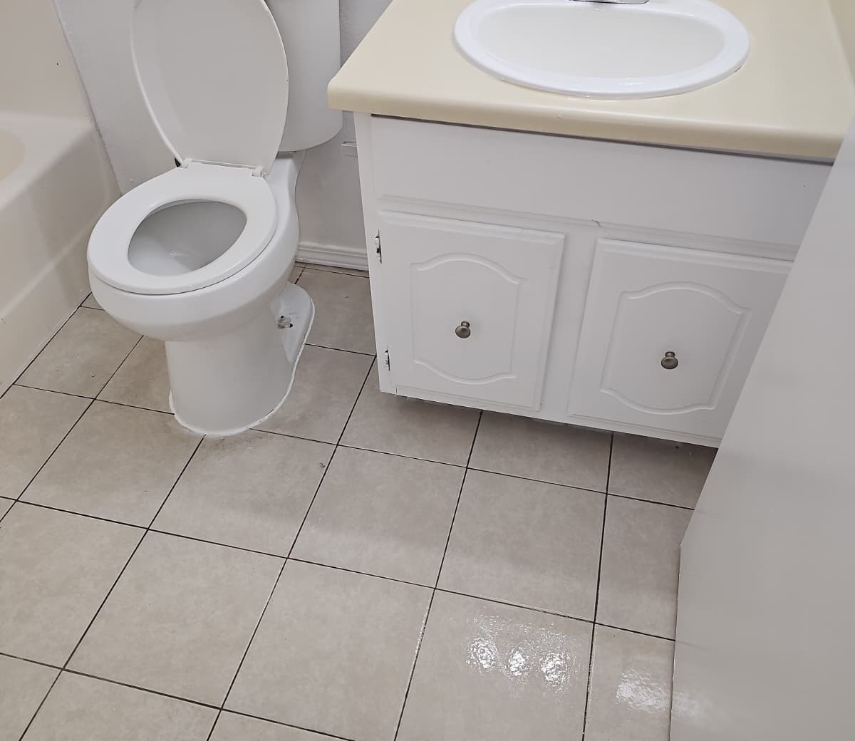 Clean bathroom tile floor around toilet and vanity
