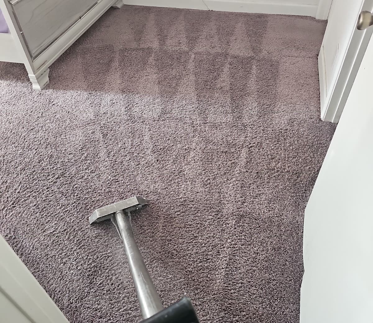Carpet extraction wand cleaning a bedroom carpet