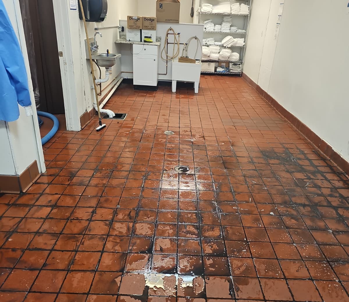 Commercial kitchen tile floor covered in grime before cleaning