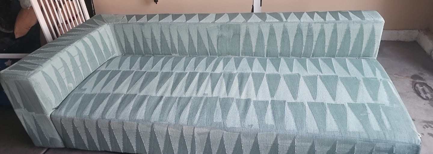 Teal patterned sofa upholstery cleaning in a garage